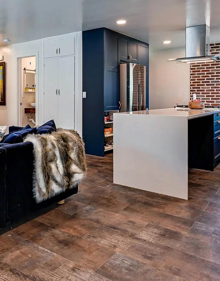 Modern Remodeled room with dark blue cupboards and waterfall island